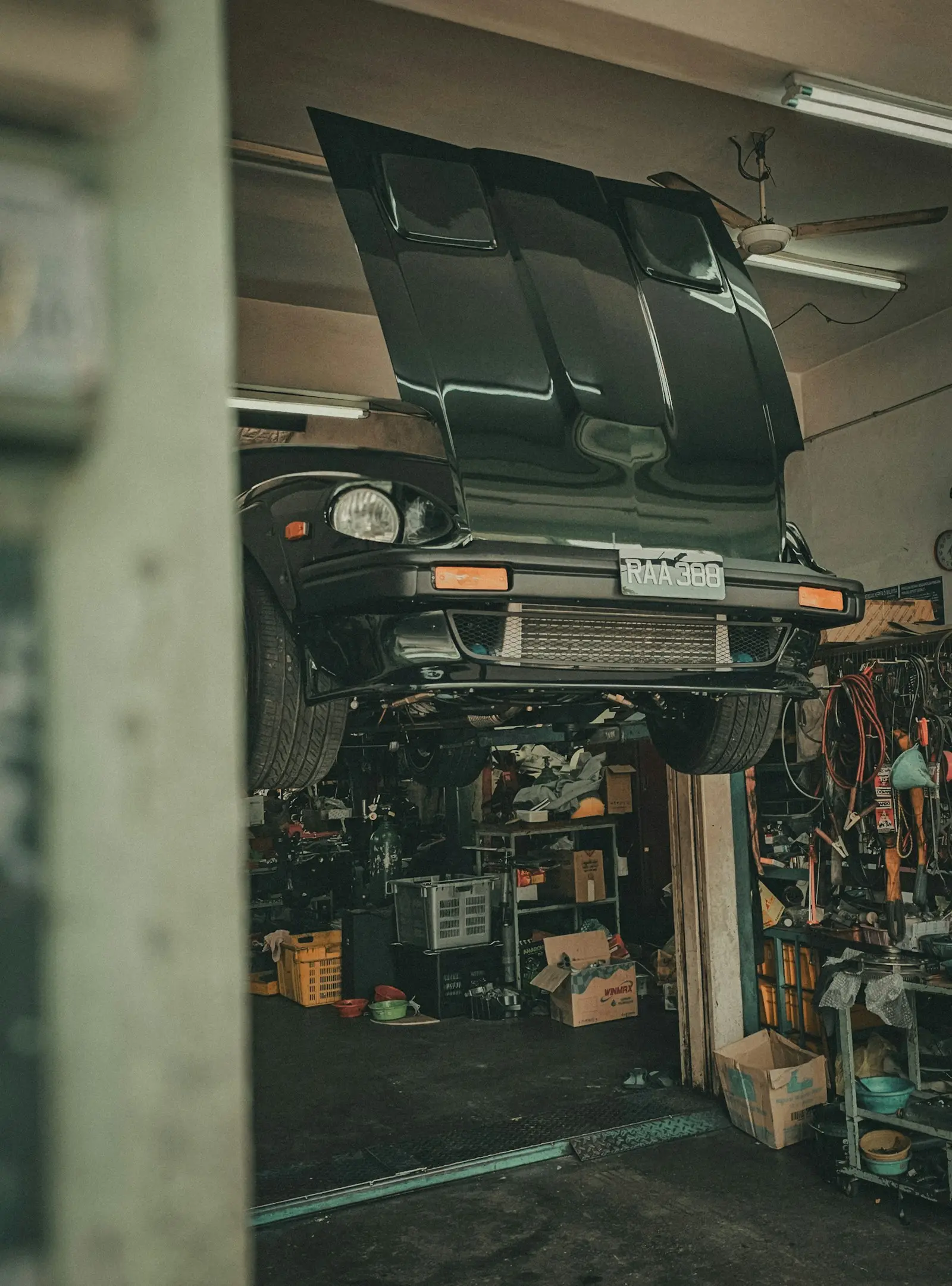 Classic coupe raised on the lift with its hood open